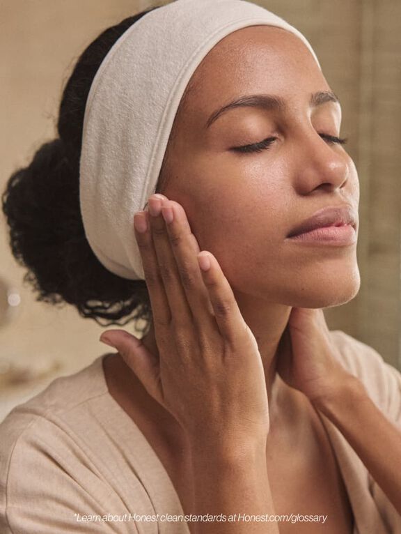 Woman lathering face with lotion