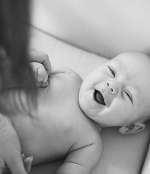 woman rubbing baby's torso