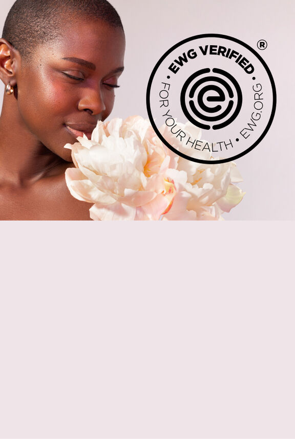 Woman smelling a flower. EWG Verified logo