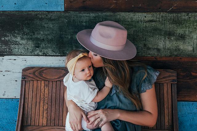 Mother kissing her baby girl on the head