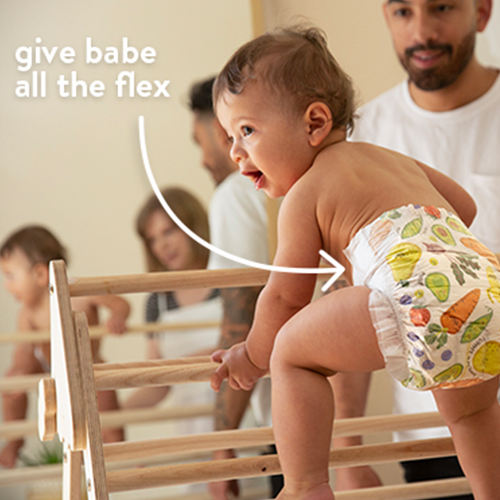 baby in so delish diaper climbing with mom and dad supervising