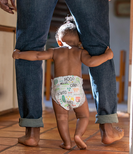 Baby walking in between dad's legs