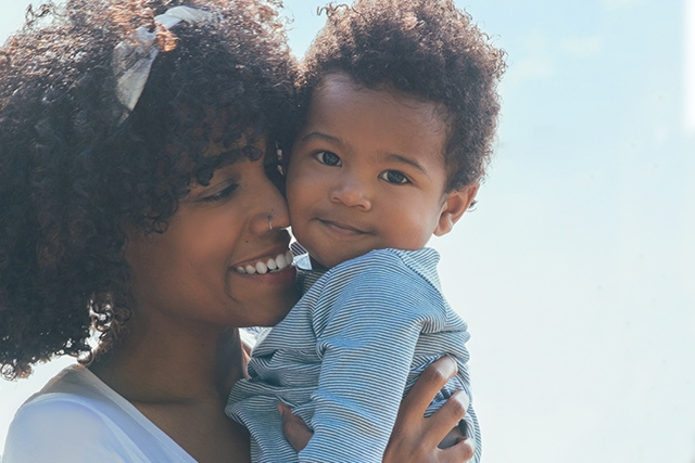 Mother holds her son while she smiles